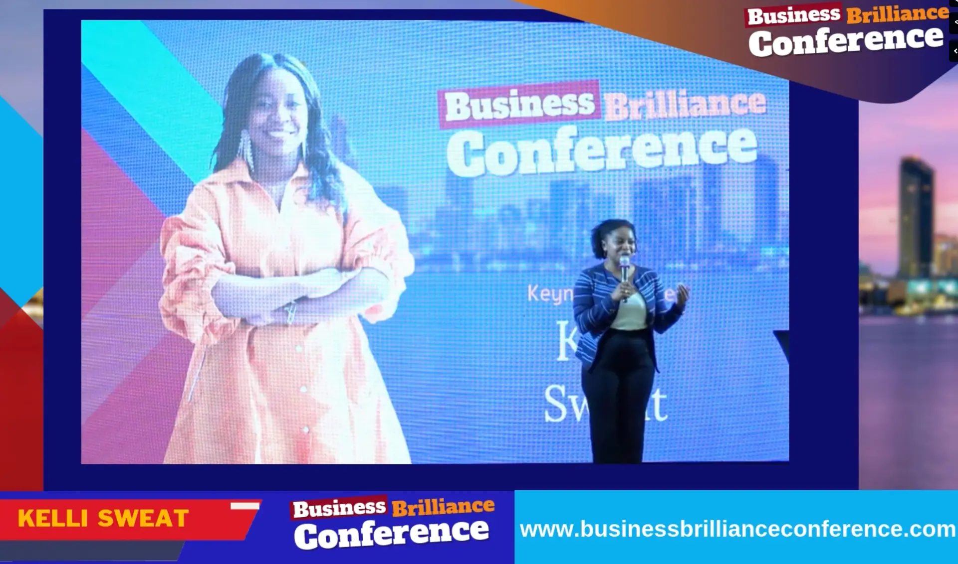 Kelli Sweat keynoting on stage at the Business Brilliance Conference, her portrait projected on the LED screen beside her